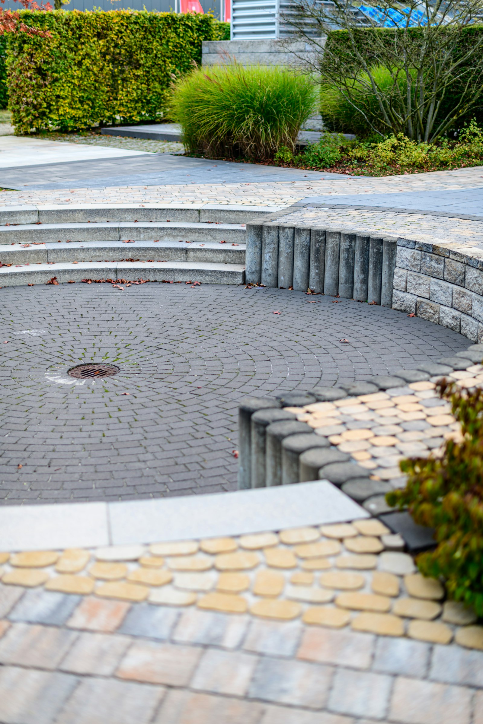 Paver patio with seating wall and lit fire pit at dusk